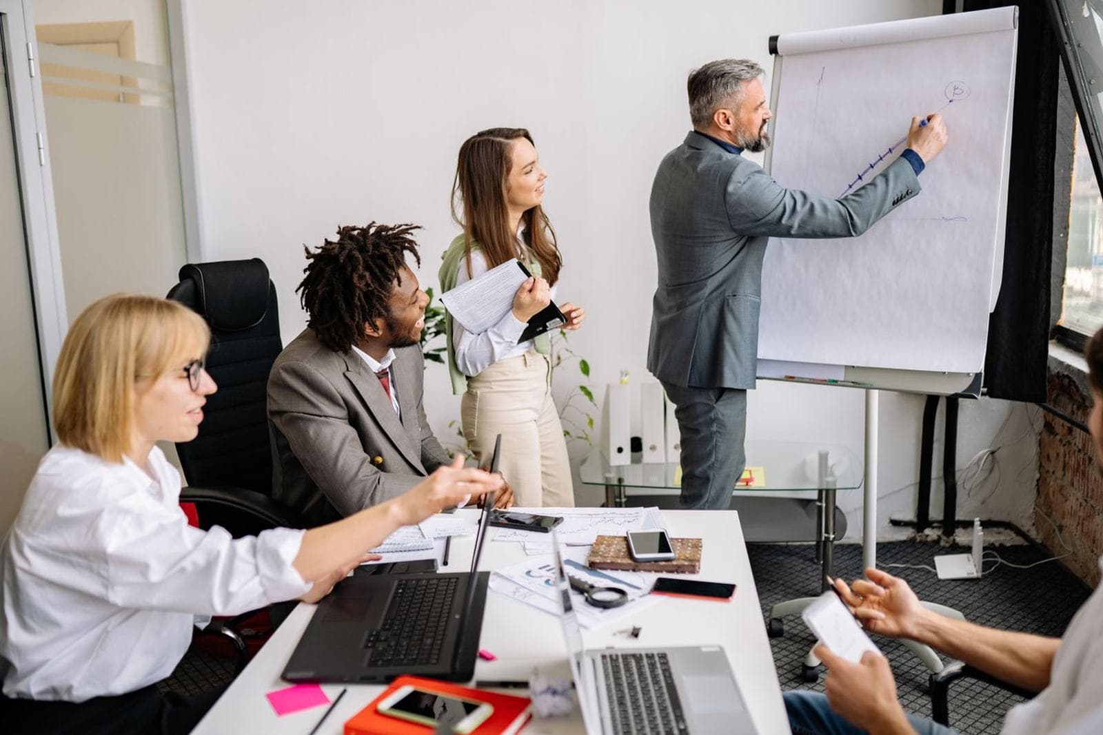 Students or professionals in a meeting, presenting, or shaking hands