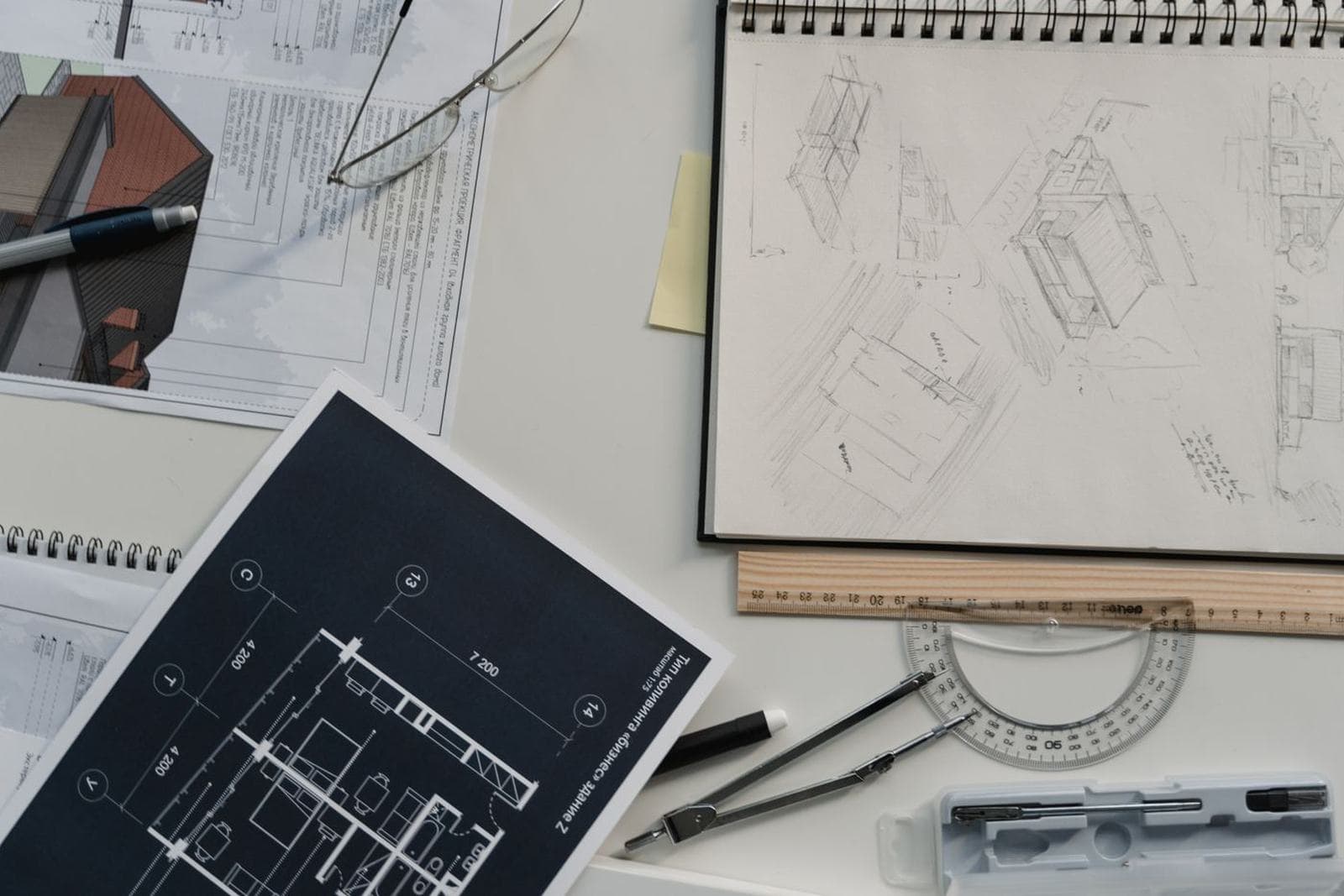 Hands drawing an architectural elevation or reviewing blueprints