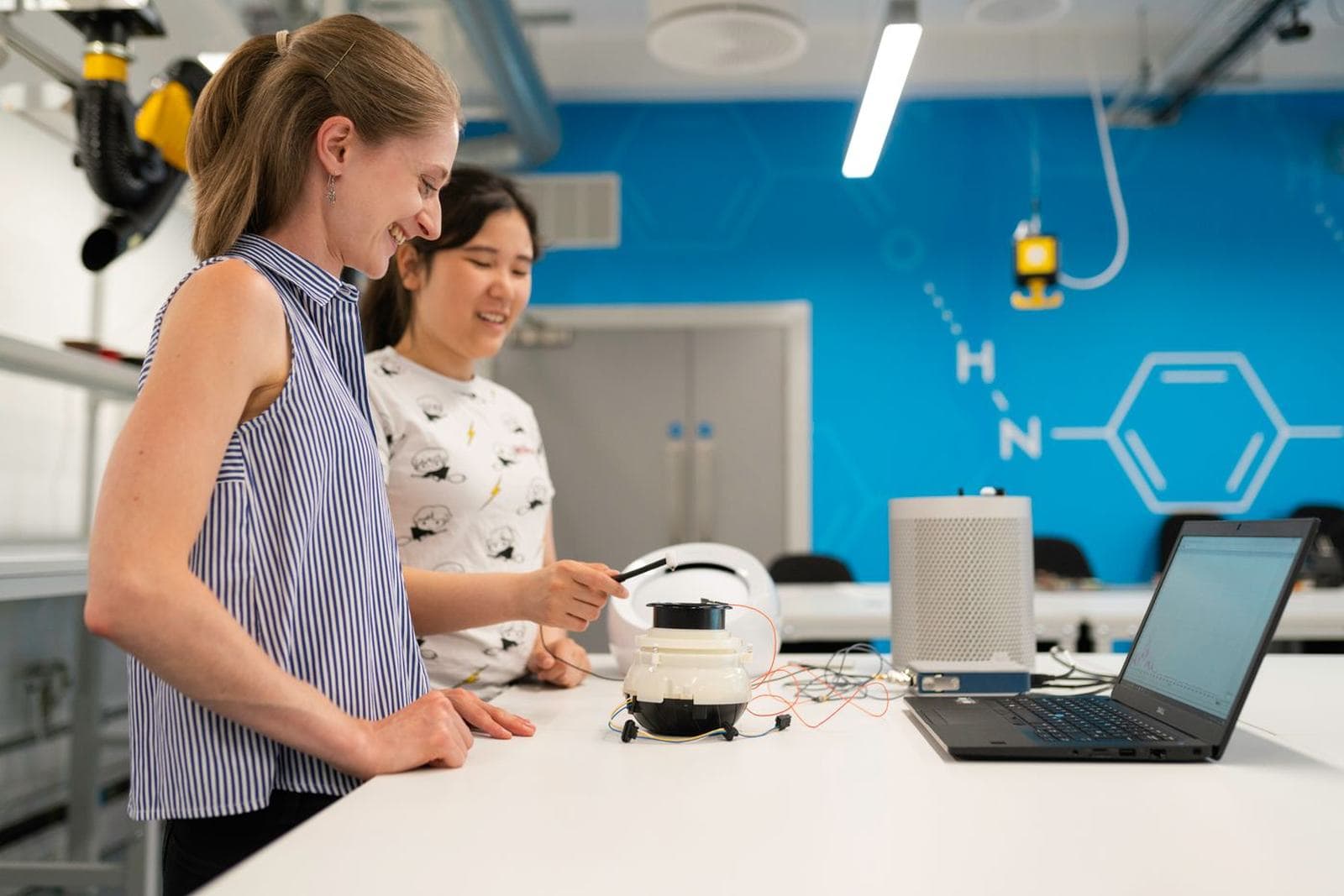 Students building and testing electronics or machinery at a workbench
