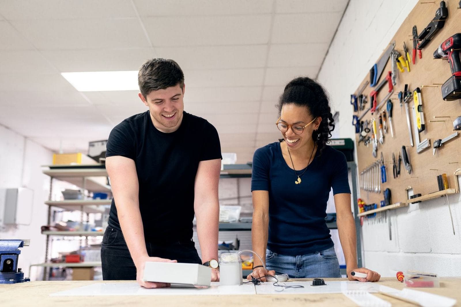 Students building and testing electronics or machinery at a workbench
