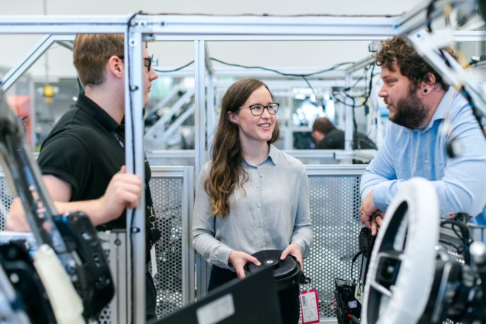 Students building and testing electronics or machinery at a workbench