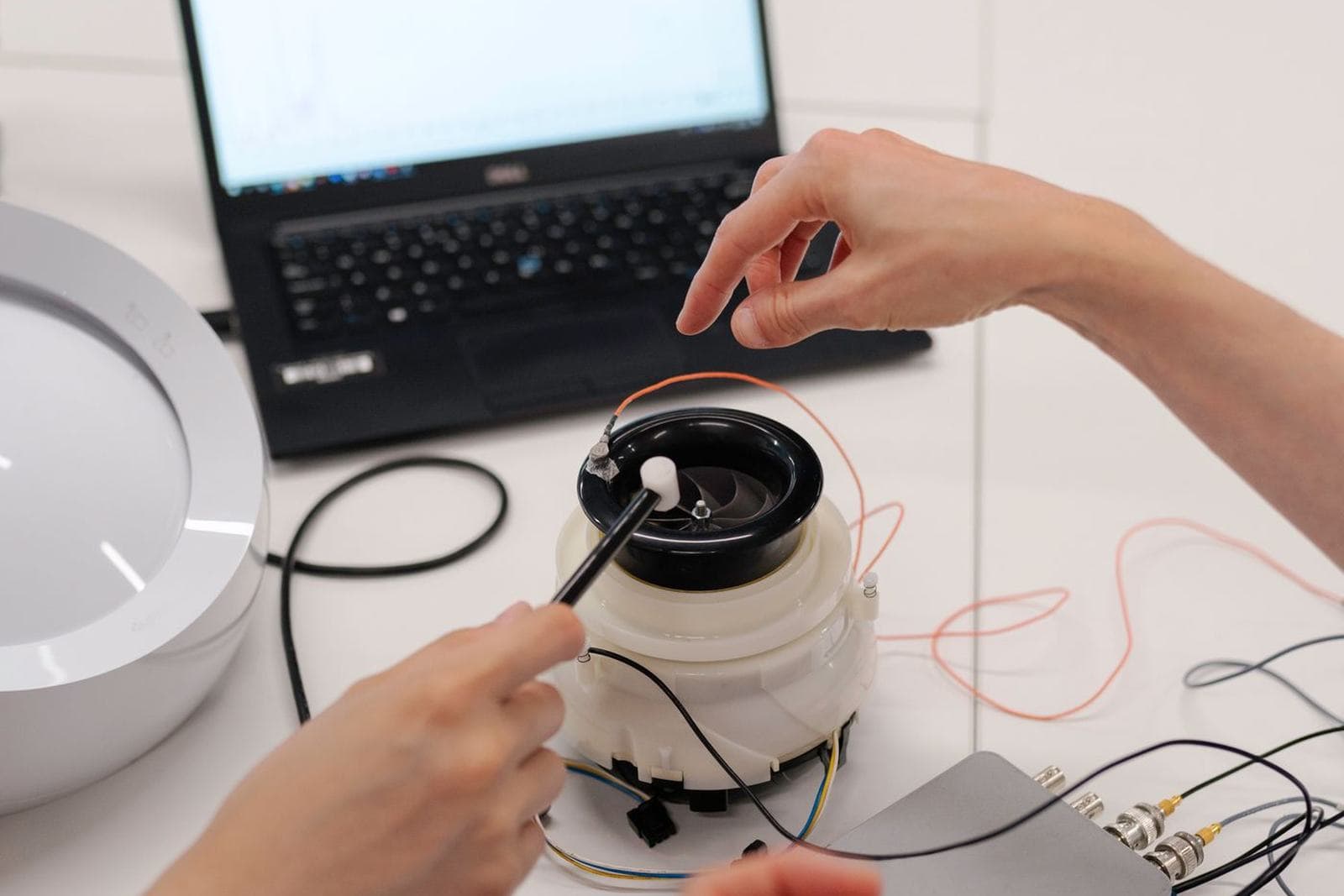 Students building and testing electronics or machinery at a workbench